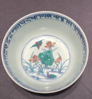 Image for post A Chinese rice bowl with a drawing of mandarin ducks in the background of a lotus pond.